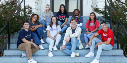 students on steps smiling