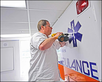 Kenneth Brull securing the ambulance in the classroom.