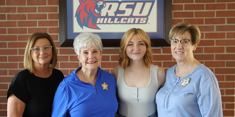 Four women standing next to each other for photo.