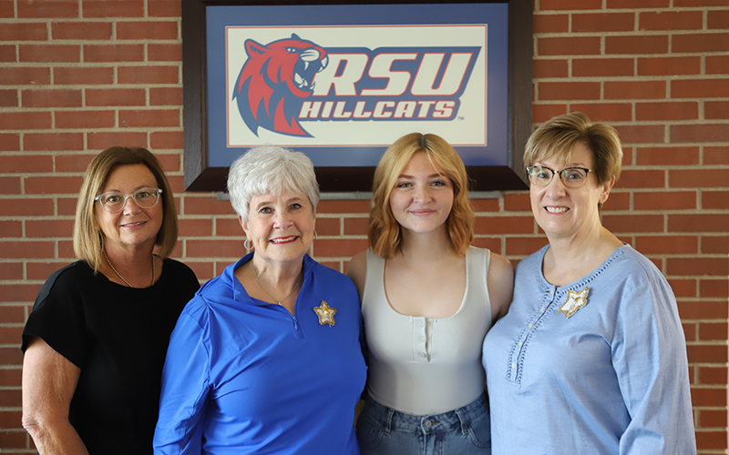 Four women standing next to each other for photo.