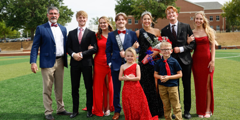 Homecoming royalty standing on soccer field.