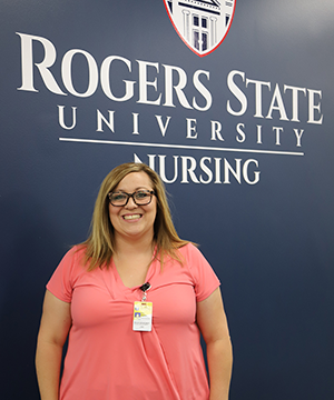 Woman standing under RSU Nursing sign