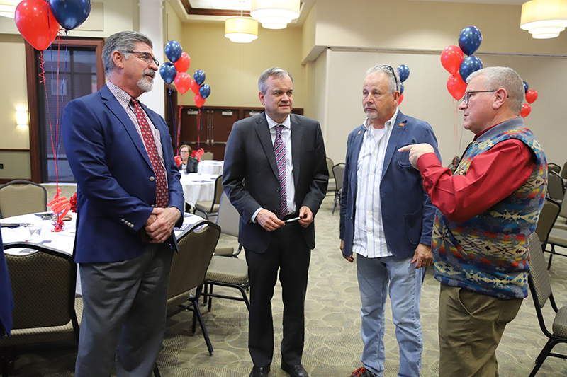 Dr. Mark Rasor (left) speaks with attendees.