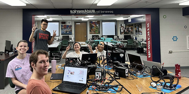 Students in classroom working on robots.