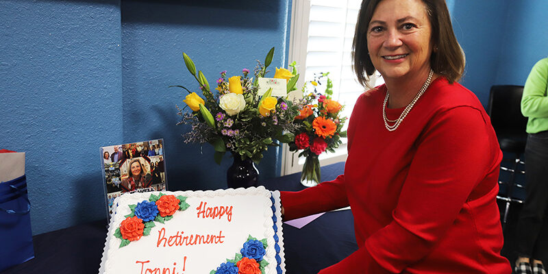 Tonni Harrald, senior director of development, shows off her retirement cake Jan. 28