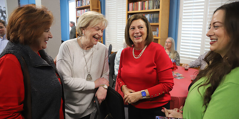 Four women laughing and talking