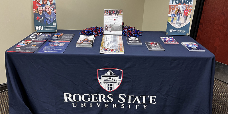 A table with a blue RSU tablecloth and various admissions marketing materials displayed on the table