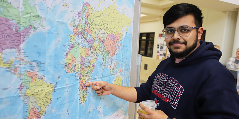 An international student places a pin on the map for his home nation.