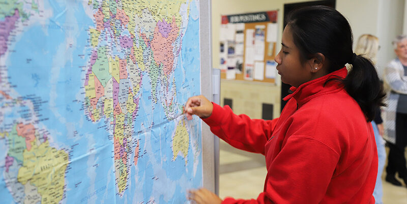 An international student places a pin on the map for her home nation.