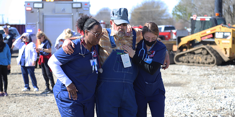 Two female RSU nursing students assist a train conductor during a mock disaster drill March 7, 2025.