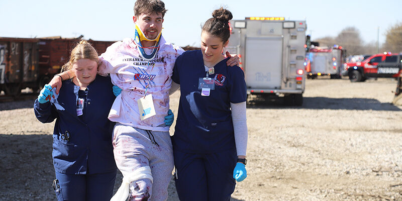 Two female RSU nursing students assist a male "victim" during a mock disaster drill March 7.