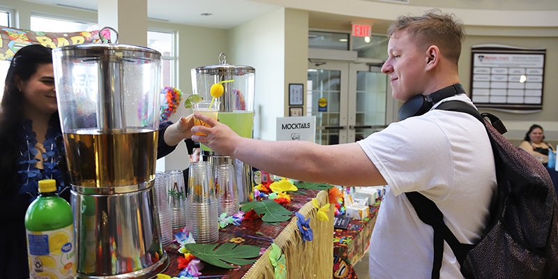 A female RSU employee serves a mocktail to an RSU student during Spring Safety Week