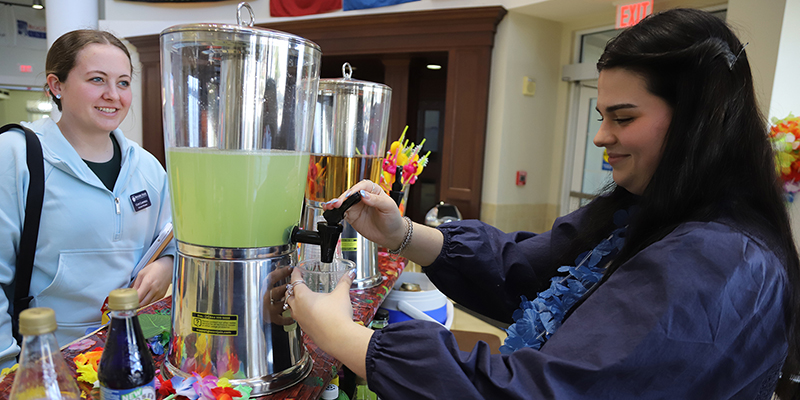 A female RSU employee serves a mocktail to an RSU student during Spring Safety Week